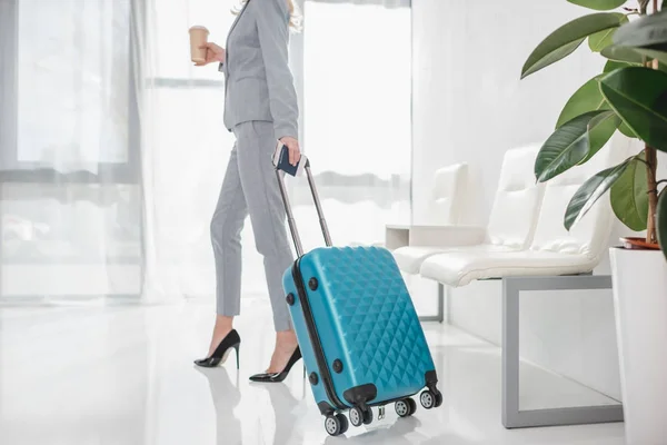 Businesswoman with luggage and coffee to go — Stock Photo
