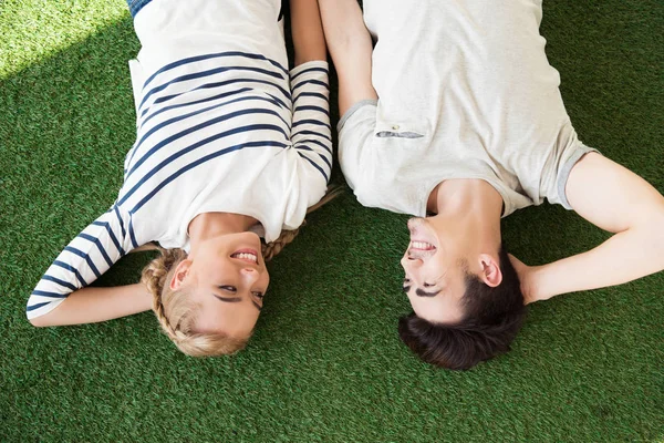 Feliz joven pareja en la hierba - foto de stock