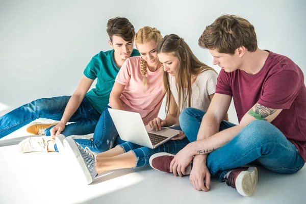 Young friends using laptop — Stock Photo