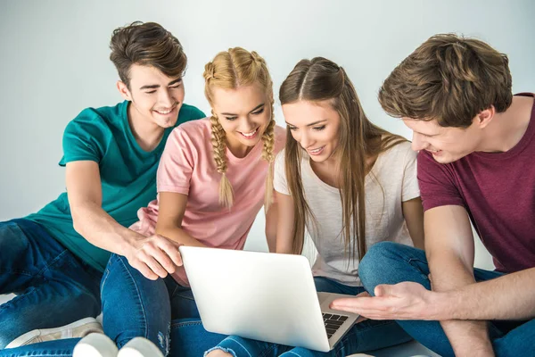 Jóvenes amigos usando laptop - foto de stock