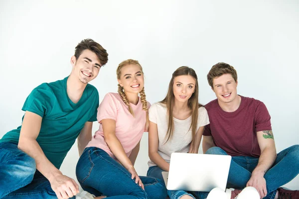 Jóvenes amigos usando laptop - foto de stock