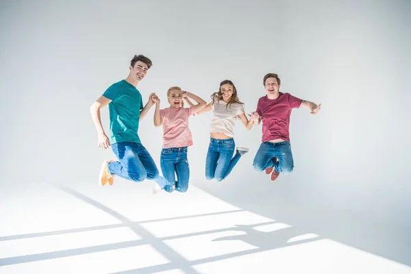 Jóvenes amigos saltando juntos - foto de stock