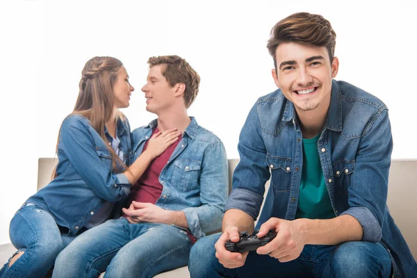 Homme avec joystick et jeune couple — Photo de stock