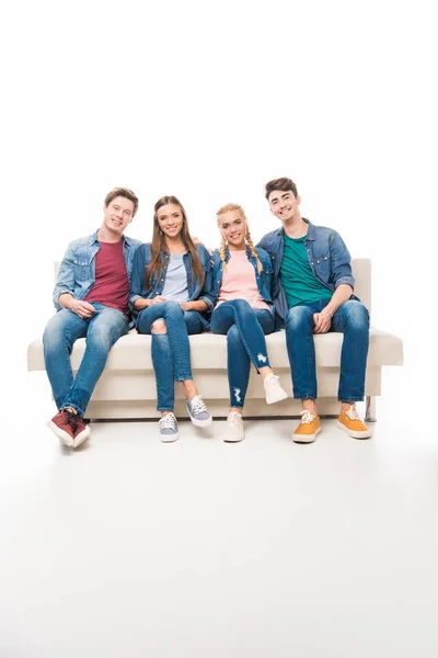 Young friends sitting on sofa — Stock Photo