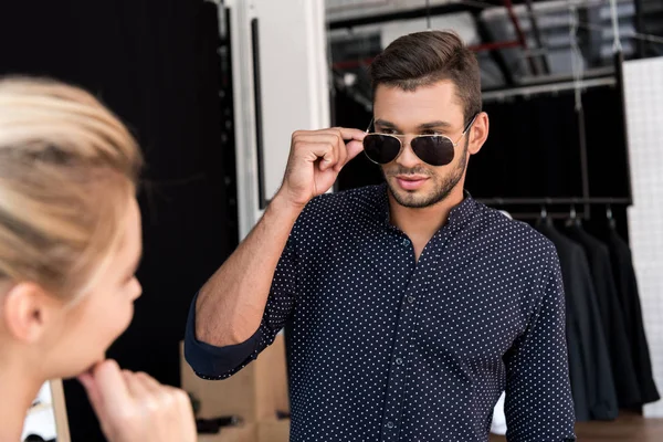 Uomo che indossa occhiali da sole in boutique — Foto stock