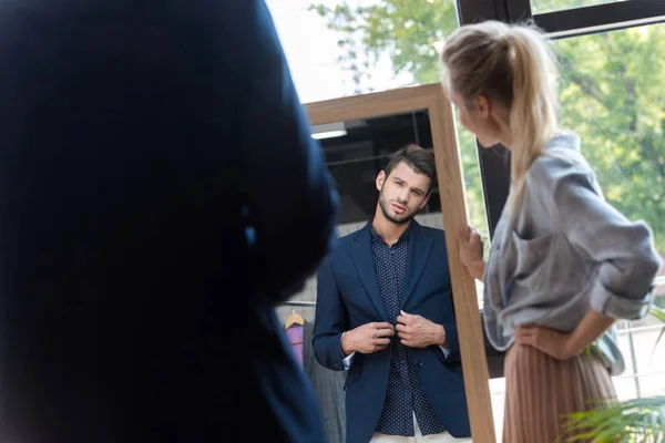 Couple choosing suit in boutique — Stock Photo