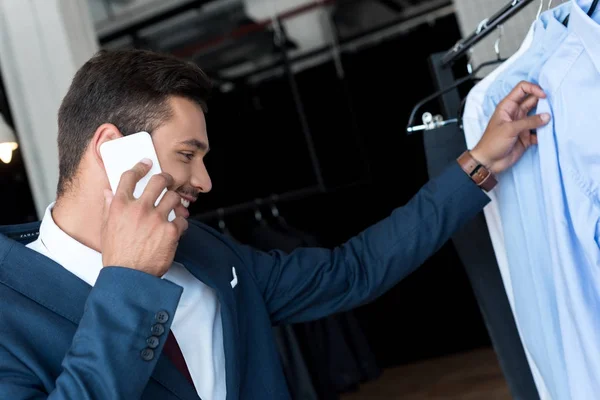 Hombre de negocios hablando en el teléfono inteligente en boutique - foto de stock