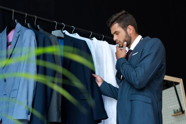 Hombre de negocios elegir traje en boutique - foto de stock