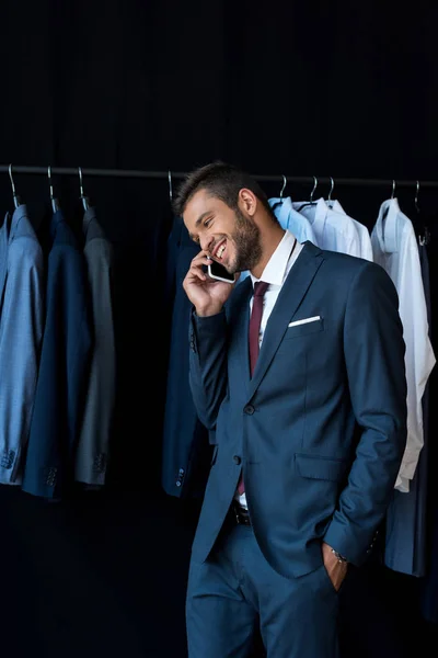 Uomo d'affari che parla su smartphone in boutique — Foto stock