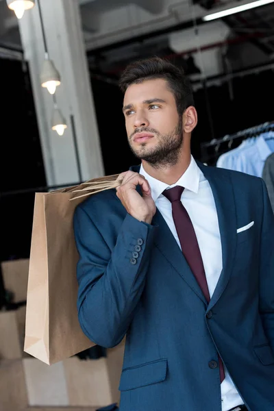 Homme d'affaires avec sacs à provisions en boutique — Photo de stock