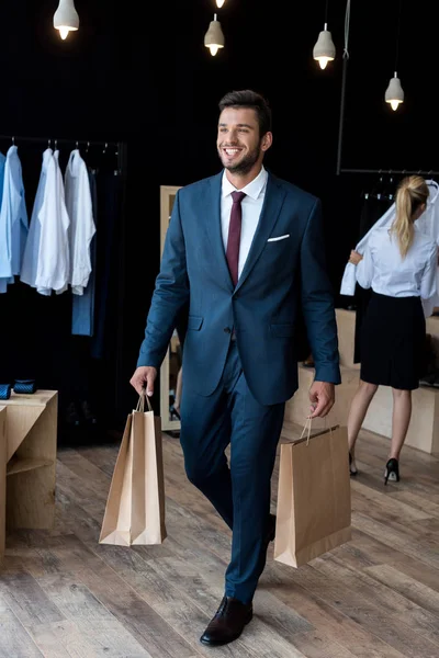 Hombre de negocios con bolsas de compras en boutique — Stock Photo