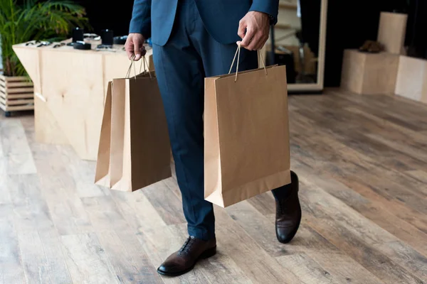Homme d'affaires avec sacs à provisions en boutique — Photo de stock