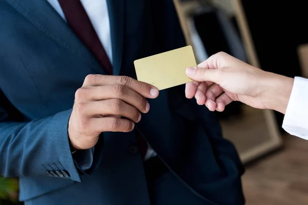 Tarjeta de tenencia de hombre de negocios y vendedor en boutique — Stock Photo