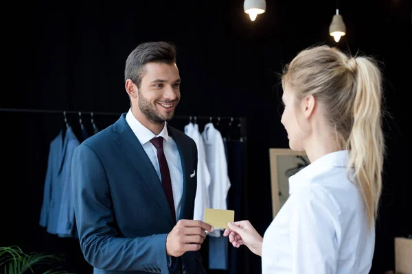 Homem de negócios e vendedor segurando cartão na boutique — Fotografia de Stock