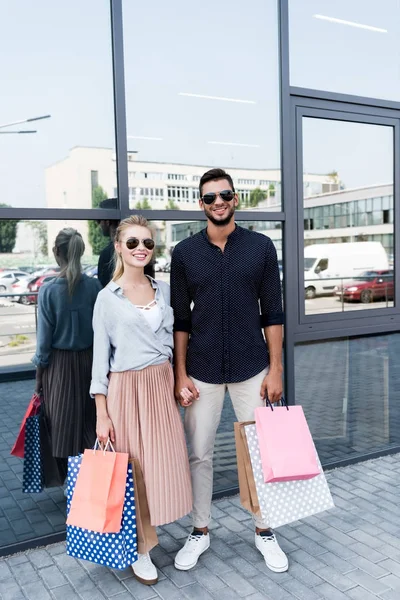 Pareja joven con bolsas de compras - foto de stock