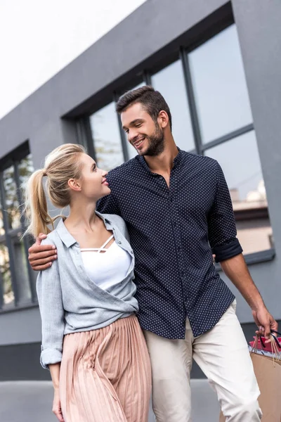 Pareja joven con bolsas de compras - foto de stock