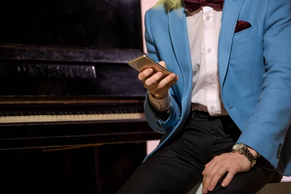 Человек с помощью смартфона на фортепиано — стоковое фото