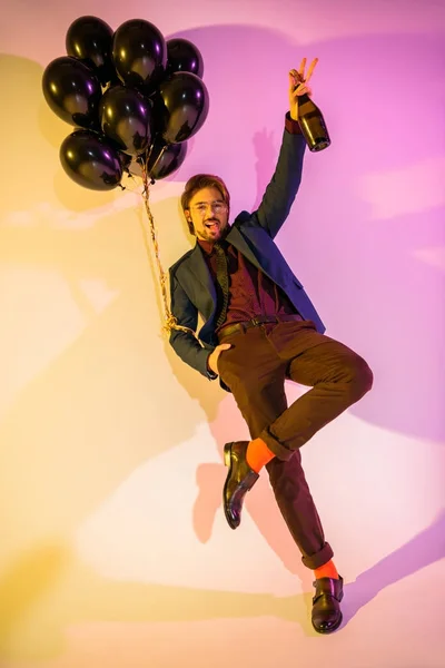 Возбужденный человек с шампанским и воздушными шарами — стоковое фото