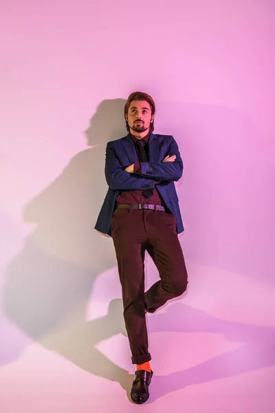 Hombre elegante posando en la pared rosa - foto de stock