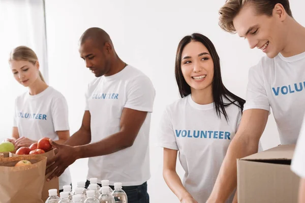 Voluntários multiétnicos que trabalham em conjunto — Fotografia de Stock