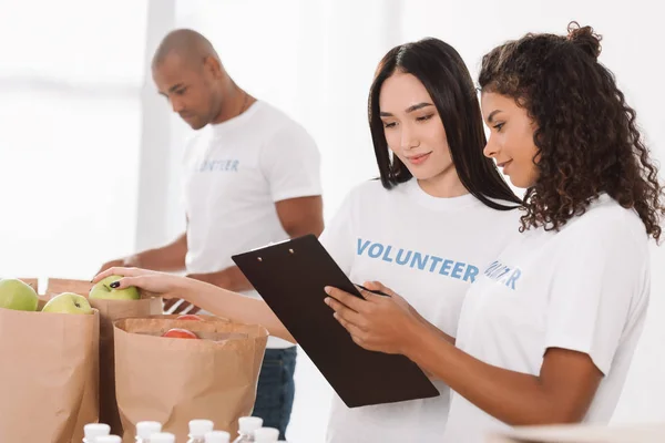 Voluntarios multiétnicos que trabajan juntos - foto de stock