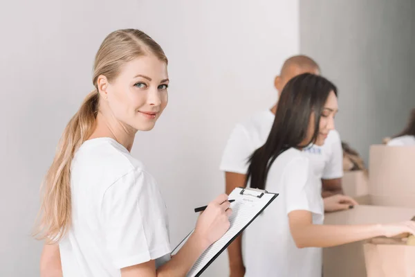 Bénévole féminine avec presse-papiers — Photo de stock