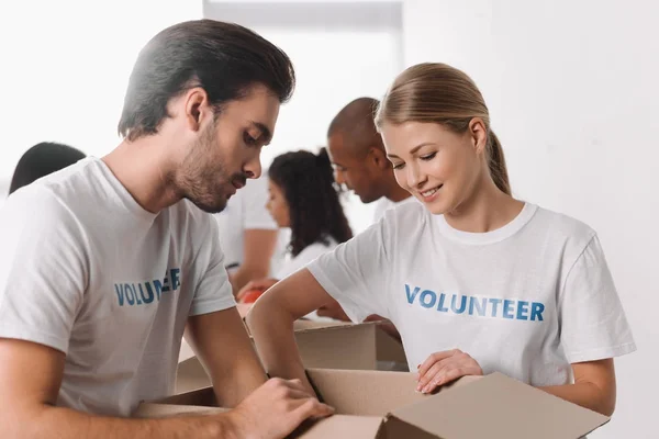 Voluntarios de embalaje de mercancías en caja - foto de stock