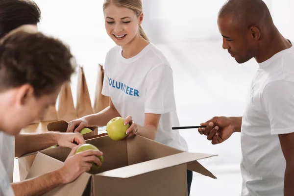 Volunteers packing food for charity — Stock Photo