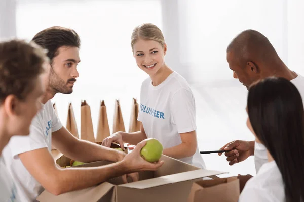 Volunteers packing food for charity — Stock Photo