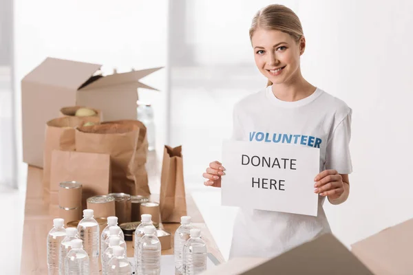 Женщина-волонтер с плакатом благотворительности — стоковое фото