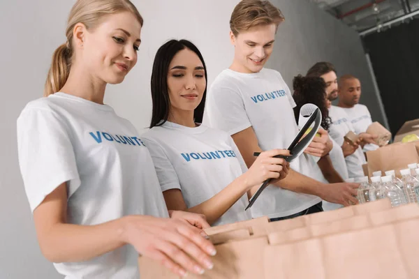 Volunteers packing food for charity — Stock Photo