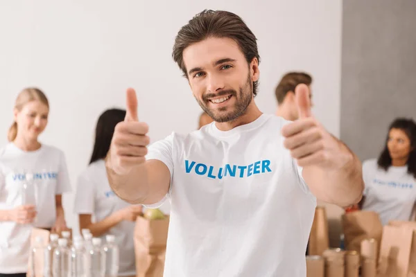 Volunteer showing thumbs up — Stock Photo