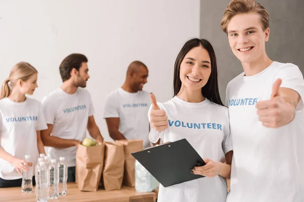 Voluntarios mostrando el pulgar hacia arriba - foto de stock