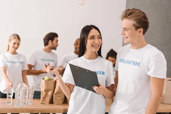 Young volunteers with clipboard — Stock Photo