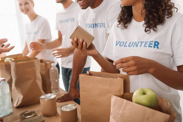 Volunteers packing food and drinks for charity — Stock Photo