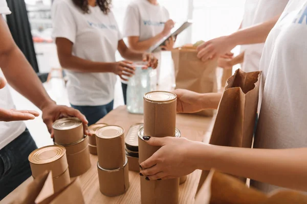 Voluntários triagem latas com alimentos — Fotografia de Stock