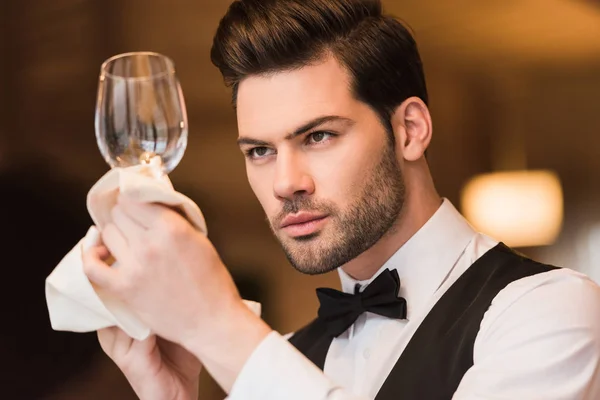 Cameriere guardando bicchiere di vino pulito — Foto stock