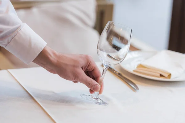 Kellner stellt leeres Weinglas auf den Tisch — Stockfoto