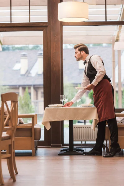 Cameriere servire piatti sul tavolo — Foto stock