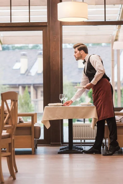 Waiter serving plates on table — Stock Photo