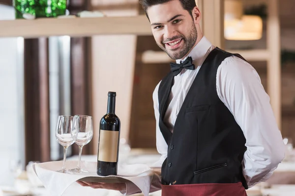 Bandeja de espera de camarero con gafas de vino y botella - foto de stock