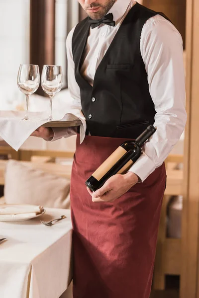 Cameriere con bicchieri da vino e bottiglia — Foto stock