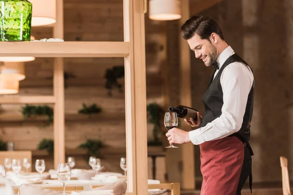 Waiter pouring red wine — Stock Photo
