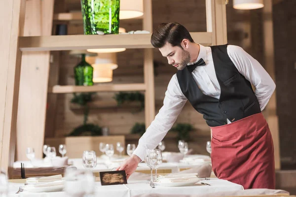 Waiter putting reserved sign — Stock Photo