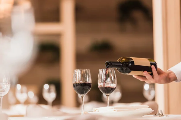 Garçom derramando vinho tinto — Fotografia de Stock