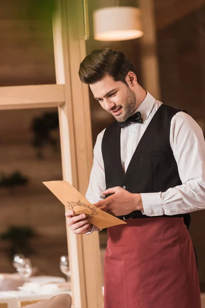 Waiter looking at menu — Stock Photo