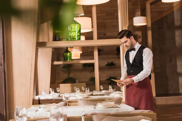 Waiter looking at menu — Stock Photo