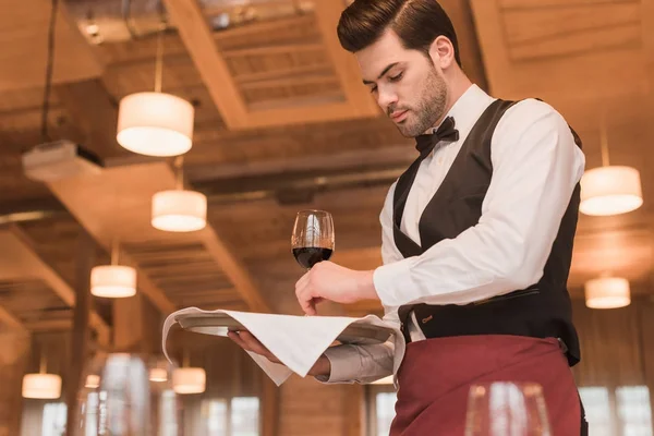 Camarero sirviendo gafas de vino en la mesa - foto de stock