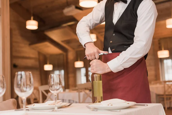 Waiter opening bottle of wine — Stock Photo