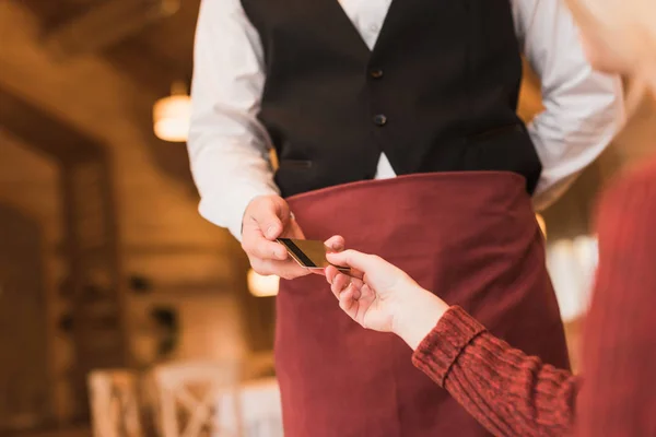 Cliente dando tarjeta de crédito al camarero - foto de stock